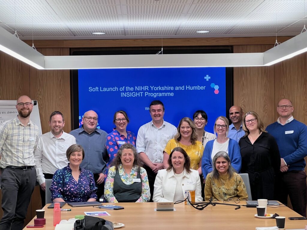 A photograph of 15 members of the Yorkshire & Humber INSIGHT group gathered around a board room table. The screen behind them reads "Soft Launch of the NIHR Yorkshire & Humber INSIGHT Programme".