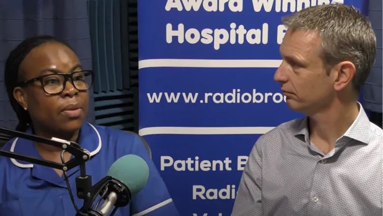 A nurse in a blue uniform and a man in a shirt talking into a microphone